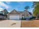 Tan house with a blue door and a two-car garage at 363 Long Meadow Dr., Loris, SC 29569