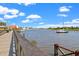 Scenic waterfront view with a wooden walkway, boats, and a clear blue sky with fluffy clouds at 92 Patriot Ct., Georgetown, SC 29440