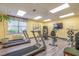 Well-lit exercise room with treadmills, stationary bike, and wall-mounted TV at 5001 Little River Rd. # E-219, Myrtle Beach, SC 29577