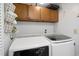Convenient laundry room with matching top-load washer and dryer and wooden upper cabinets at 6706 Bryant St. # B, Myrtle Beach, SC 29572