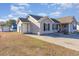 Tan house exterior with red front door, attached garage, and landscaping at 1049 Augustus Dr., Conway, SC 29527