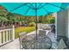 Relaxing patio with table and chairs, umbrella, and a view of the backyard at 130 Balsa Dr., Longs, SC 29568