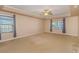 Large main bedroom with carpet flooring, window with blinds, and ceiling fan at 588 Tourmaline Dr., Little River, SC 29566