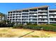 Exterior view of a multi-story building with balconies and landscaping at 5905 S Kings Hwy. # B130, Myrtle Beach, SC 29575