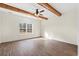 Spacious bedroom features wood beams, hardwood floors, and abundant natural light from the large window at 800 Caines Landing Rd., Conway, SC 29526