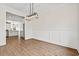 Open dining room with wood floors and decorative wainscoting, flowing seamlessly into the adjacent kitchen at 800 Caines Landing Rd., Conway, SC 29526