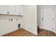 Clean and bright laundry area features white cabinets, laminate floors, and essential utility connections at 800 Caines Landing Rd., Conway, SC 29526