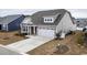 Tan house with a gray roof, two-car garage, and manicured lawn at 1262 Witch Hazel Way, Longs, SC 29568