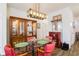 Dining room with glass table, red chairs, and a wooden display cabinet at 127 Marauder Dr., Longs, SC 29568