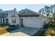 Inviting single-story home with a manicured lawn, one-car garage and light-colored siding at 127 Marauder Dr., Longs, SC 29568