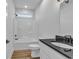 Bright bathroom featuring a shower-tub, black hardware, wood-look floor, and a sleek vanity with a black countertop at 33 Captains Pl, Murrells Inlet, SC 29576