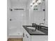 Bright bathroom featuring a shower-tub, black hardware, wood-look floor, and a sleek vanity with a black countertop at 33 Captains Pl, Murrells Inlet, SC 29576