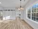Bright, open living area with wood-look floors and a stylish chandelier for modern comfort at 33 Captains Pl, Murrells Inlet, SC 29576