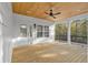 Covered porch with stained wood planking ceiling and floors, black railing, and peaceful wooded view at 33 Captains Pl, Murrells Inlet, SC 29576