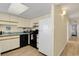 Kitchen with white appliances and view into hallway at 4619 S Ocean Blvd. # 207, North Myrtle Beach, SC 29582