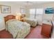 Cozy bedroom featuring twin beds, a TV, and a window bringing in natural light at 507 S Ocean Blvd. # 201, North Myrtle Beach, SC 29582