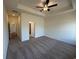 Large carpeted bedroom with a ceiling fan, tray ceiling, and doorways leading to other areas of the home at 541 Honeyhill Loop, Conway, SC 29526