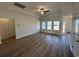 Bright living room with wood-look floors, a tray ceiling, and ample natural light from windows at 541 Honeyhill Loop, Conway, SC 29526