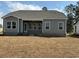 View of the back of the home with a covered patio and a large grassy backyard space at 541 Honeyhill Loop, Conway, SC 29526