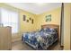 Comfortable bedroom featuring a queen bed with decorative blue floral comforter and yellow walls at 6001 South Kings Hwy., Myrtle Beach, SC 29575
