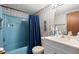 Clean bathroom with blue bathtub and shower, white vanity, and patterned wallpaper at 6001-5732 S Kings Hwy., Myrtle Beach, SC 29575
