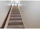 Carpeted staircase with a wooden handrail leading upstairs to the upper level of the house at 645 Retreat Beach Circle, Pawleys Island, SC 29585