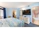 Serene bedroom with balcony access, TV, dresser, and ensuite bathroom at 7100 Ocean Blvd. # 223, Myrtle Beach, SC 29572