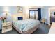 Cozy bedroom with balcony access, bedside tables, lamps, and an ocean-themed decor at 7100 Ocean Blvd. # 223, Myrtle Beach, SC 29572