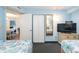 Well-lit bedroom with two beds, closet, and large TV with a view to the rest of the condo at 7100 Ocean Blvd. # 223, Myrtle Beach, SC 29572