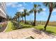 Manicured lawn area with lounge chairs next to a beach with a fence and palm trees at 7100 Ocean Blvd. # 223, Myrtle Beach, SC 29572