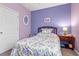 Charming bedroom with lavender walls, floral bedding, and a nightstand at 747 Coquina Bay Dr., Conway, SC 29526