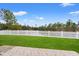 Expansive green backyard with a white picket fence and lake views from the outdoor patio space at 817 Payne Ct., Conway, SC 29526