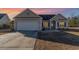 Charming single-story home with a well-lit entrance, two-car garage, and a neatly maintained driveway as the sun sets at 817 Payne Ct., Conway, SC 29526