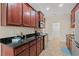 Spacious kitchen boasting dark wood cabinets, granite countertops, stainless steel appliances and access to another room at 817 Payne Ct., Conway, SC 29526