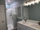 Modern bathroom with a double sink vanity, walk-in shower with glass enclosure and bright vanity lighting at 931 Edge Dr., North Myrtle Beach, SC 29582