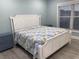 Bright bedroom featuring a white wood bed frame, colorful bedding, and a window allowing natural light at 931 Edge Dr., North Myrtle Beach, SC 29582