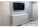 Bedroom with a white dresser and a wall-mounted TV for entertainment, complemented by a fresh, airy design at 931 Edge Dr., North Myrtle Beach, SC 29582