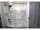 Clean bathroom featuring a tub/shower combo with curved sliding glass doors at 9620 Windchime Dr., Myrtle Beach, SC 29572