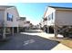 Street view of raised beach homes with covered parking underneath on a sunny day at 9620 Windchime Dr., Myrtle Beach, SC 29572