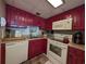 Bright kitchen with red cabinets, microwave, and dishwasher at 1210 N Waccamaw Dr. # 702, Murrells Inlet, SC 29576