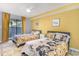 Bedroom with two twin beds, yellow walls, and floral bedding at 211 Baslow Ct. # 2-C, Myrtle Beach, SC 29572