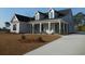Beautifully landscaped single-Gathering home with a concrete driveway and a welcoming front porch with white columns at 2220 Pettus Way, Surfside Beach, SC 29575