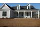 Charming single-Gathering home featuring a welcoming front porch with stylish columns and neutral-colored siding at 2220 Pettus Way, Surfside Beach, SC 29575