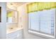 Bathroom with a white vanity, bright window, and yellow accents bringing natural light into the room at 6001-Z16 S Kings Hwy., Myrtle Beach, SC 29575