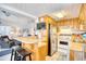 Cozy kitchen with wood cabinets, breakfast bar, stainless steel refrigerator, and white appliances at 6001-Z16 S Kings Hwy., Myrtle Beach, SC 29575