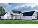 White farmhouse with a two car garage and landscaping at 2172 Pettus Way, Surfside Beach, SC 29575