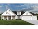 Two-story farmhouse with white siding, dark roof, and a three-car garage at 2188 Pettus Way, Surfside Beach, SC 29575