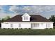 White farmhouse with dark roof, multiple windows, and a back patio at 2188 Pettus Way, Surfside Beach, SC 29575