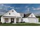 Modern farmhouse exterior with white siding, black accents, and a three-car garage at 2188 Pettus Way, Surfside Beach, SC 29575