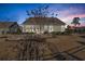 Spacious landscaped backyard with a stone patio, an outdoor grill, green lawn, and view of a well-maintained home at 1405 Osprey Pointe Ln., North Myrtle Beach, SC 29582